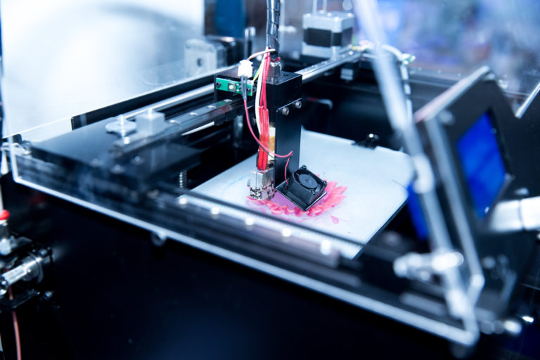 Delta-style 3D printer depositing filament