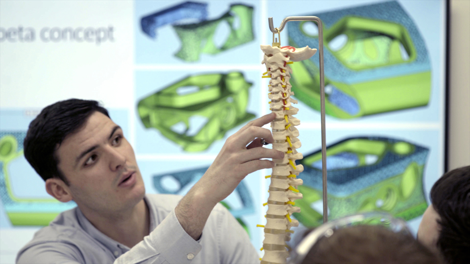 Person holding a model of the spine