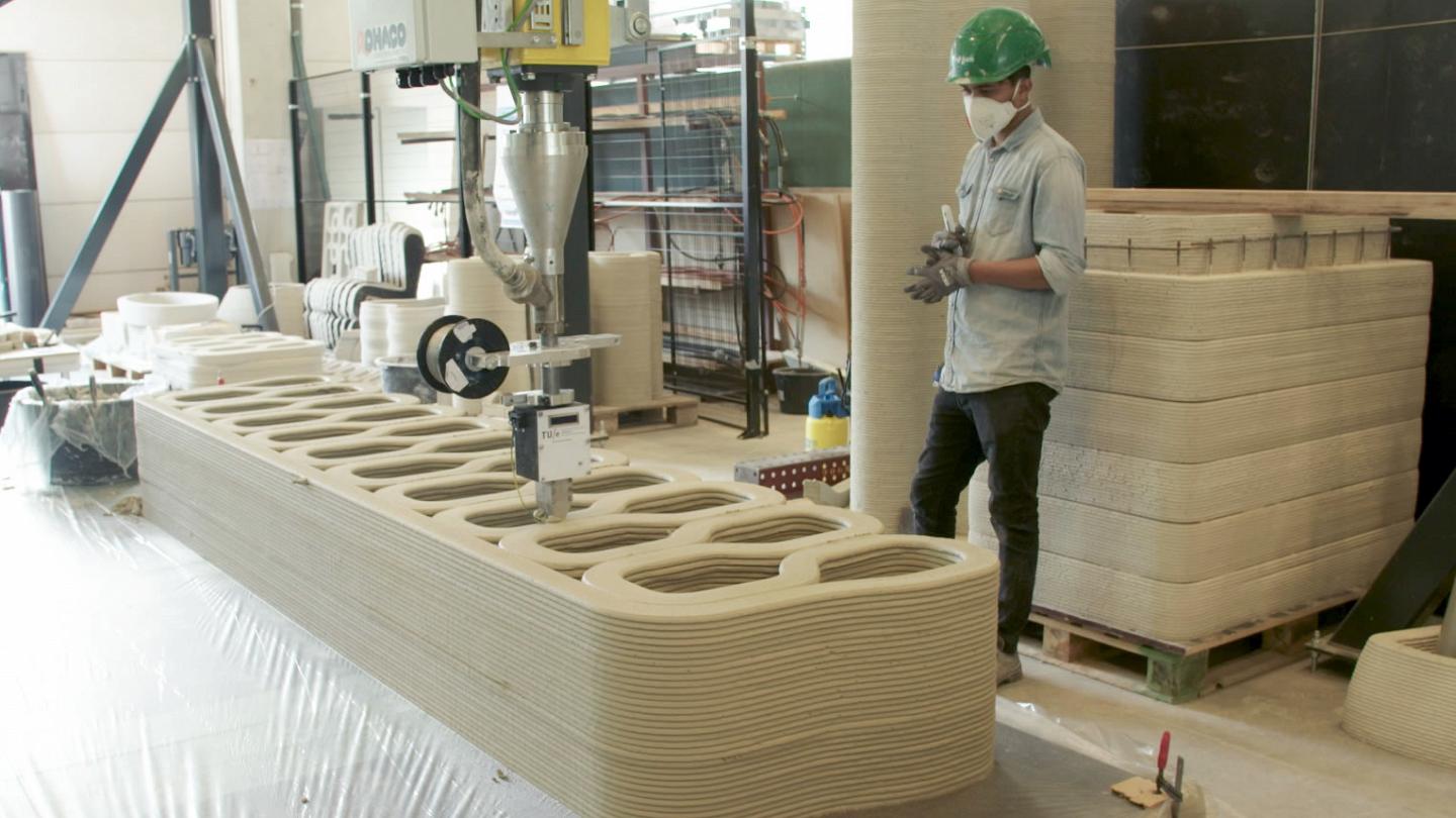 Operator beside concrete-printing equipment