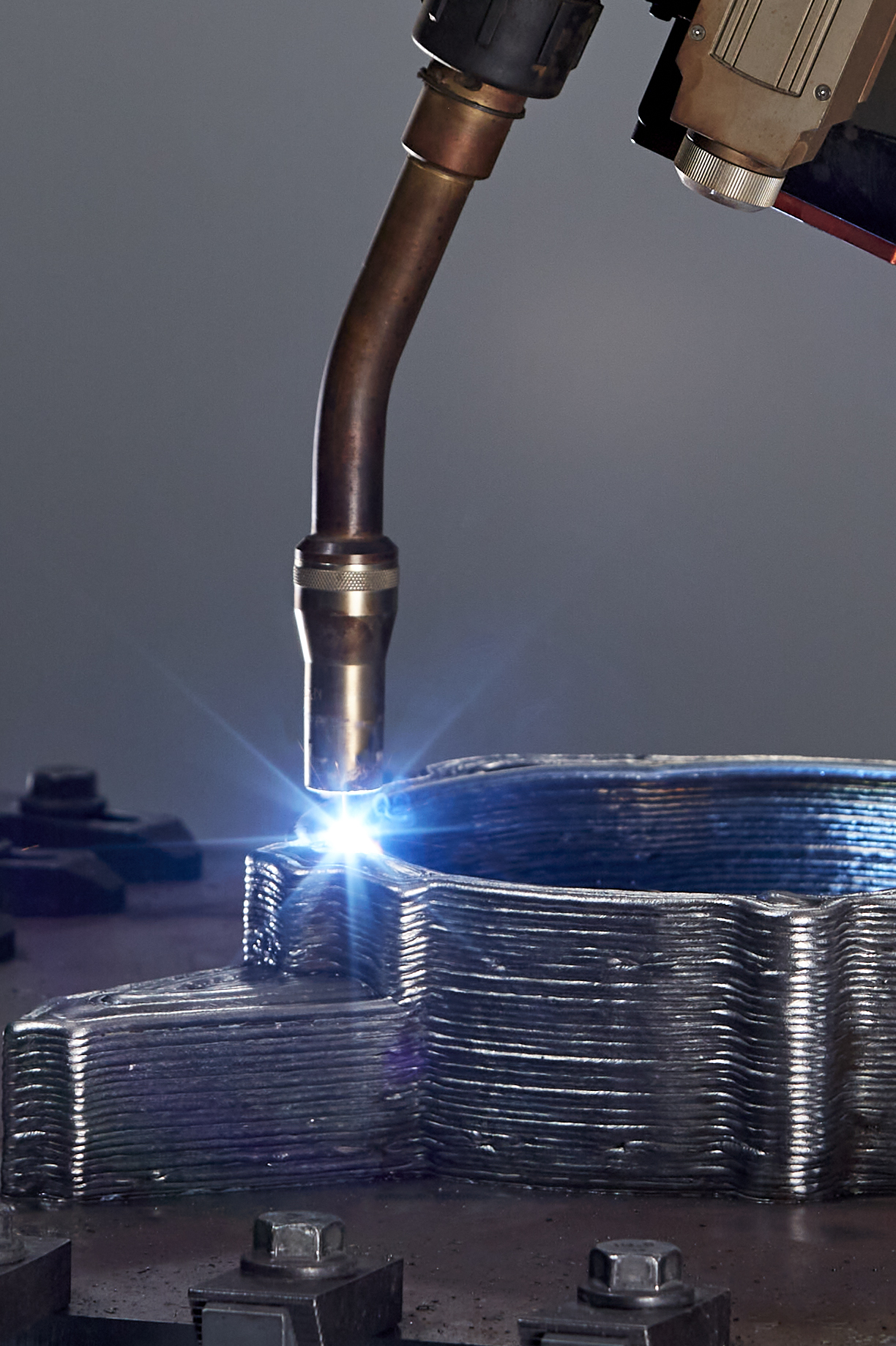 Metal housing showing wire-arc deposition beads