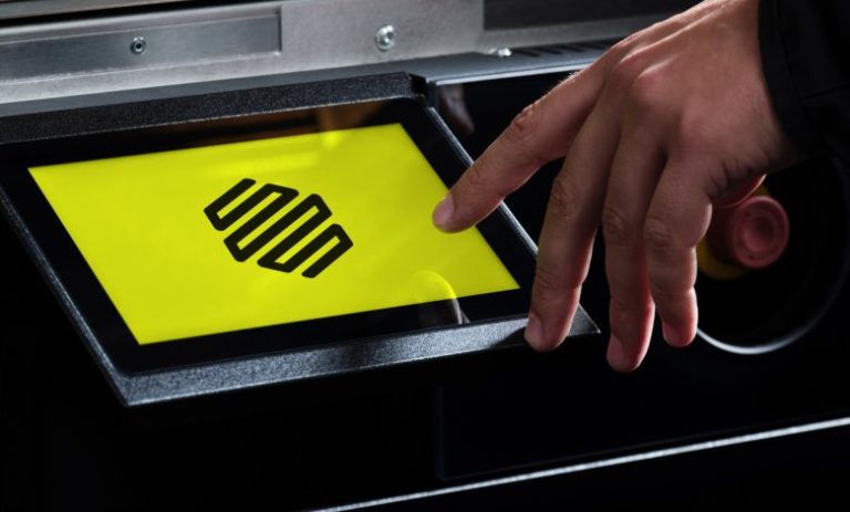 A person operates a touchscreen on manufacturing equipment.
