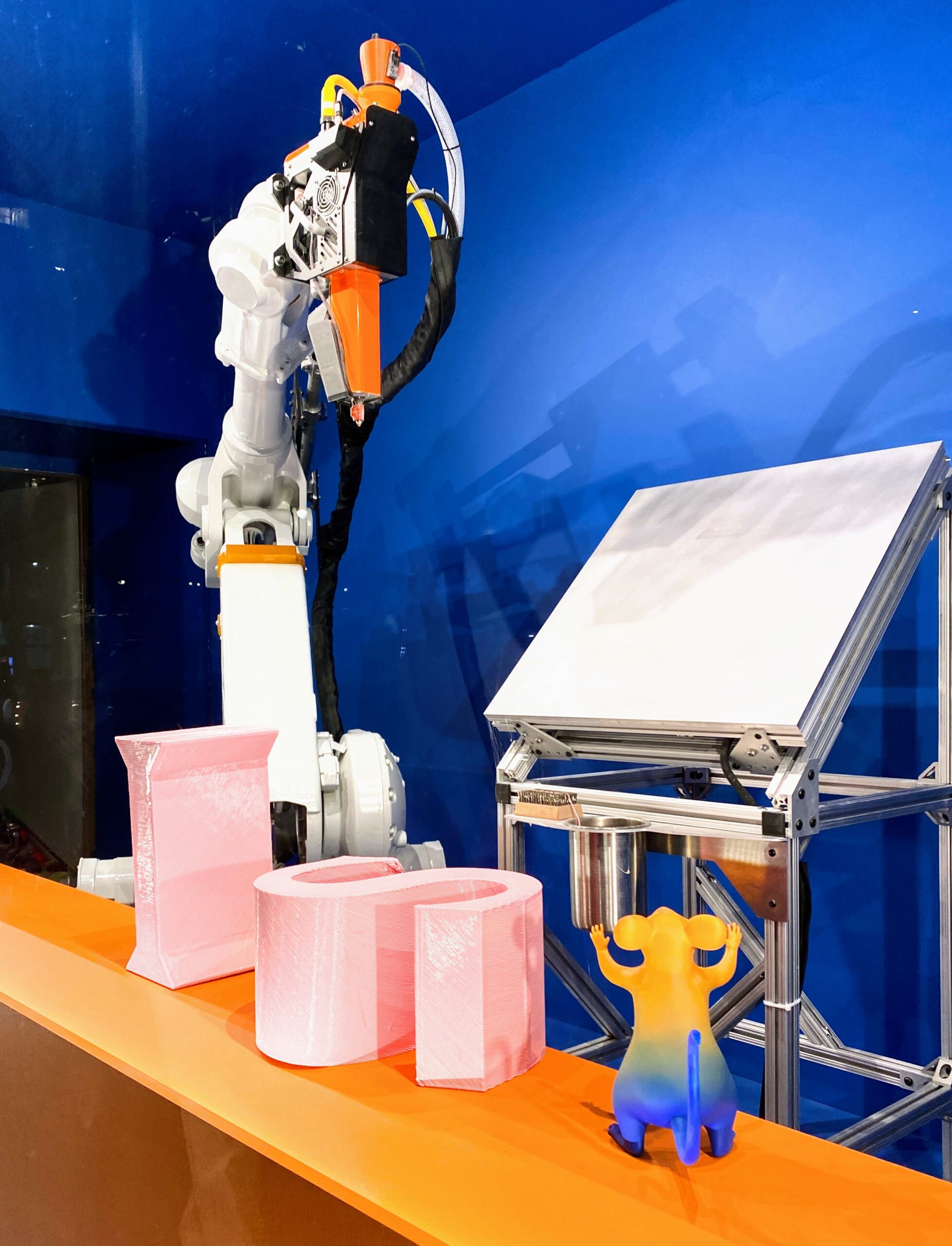Robotic arm and demonstration parts displayed on a stand