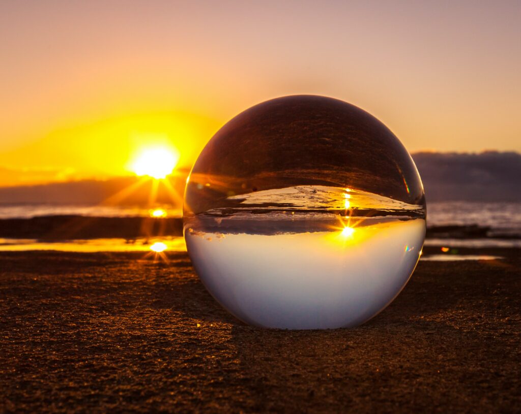 Sunset landscape viewed through a glass ball — Photoholgic / Unsplash