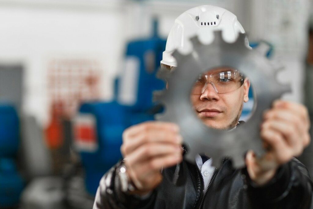 Technician examining a toothed metal component
