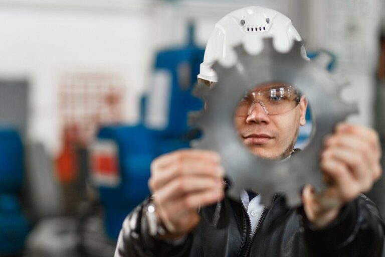 Technicien examinant une pièce métallique dentée