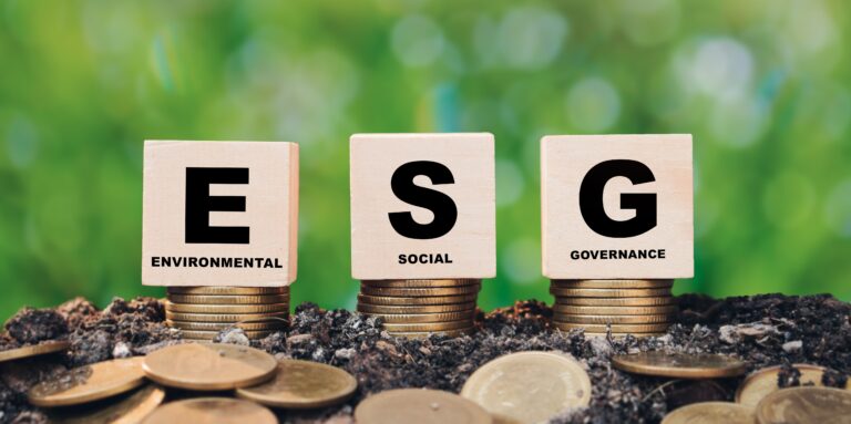 Blocs ESG sur des piles de pièces, illustrant environnement, social et gouvernance