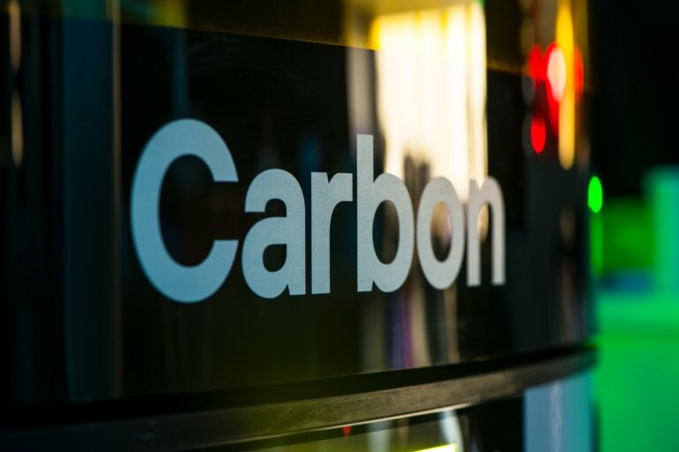 Carbon logo on a dark glass surface.