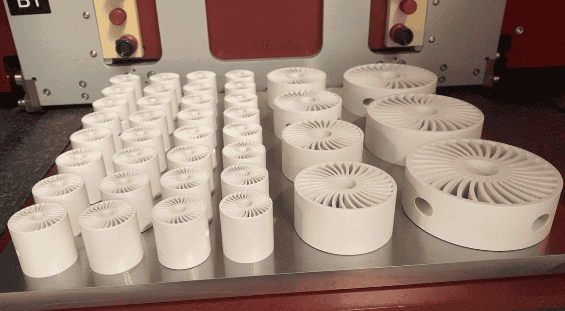 Pièces céramiques blanches de plusieurs diamètres disposées sur le plateau de la C1000 FLEXMATIC
