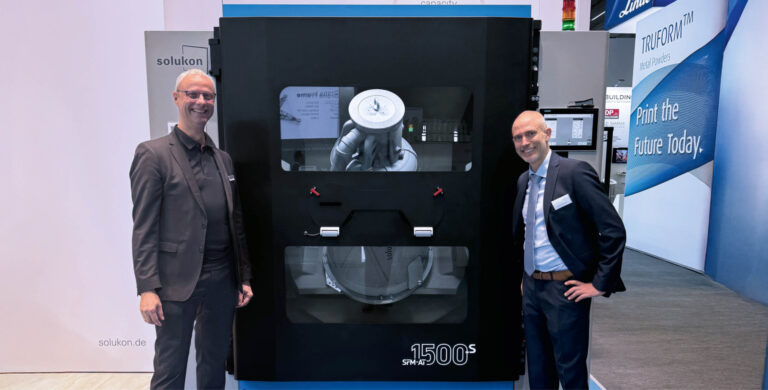 Martin Bullemer et Andreas Hartmann devant le Solukon SFM-AT1500-S au salon Formnext 2024.