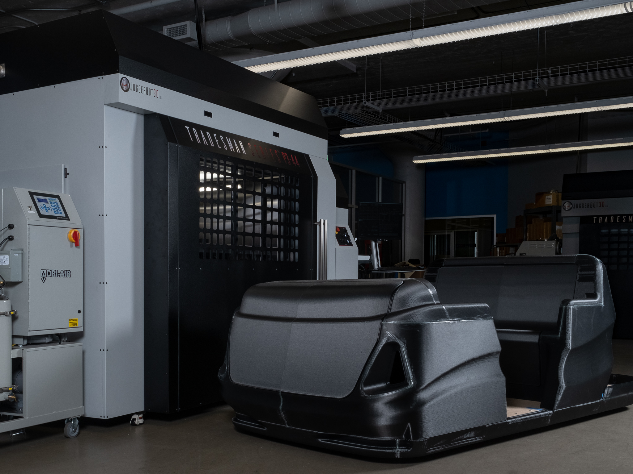 People mover cabin printed in ABS CF20 beside a JuggerBot system