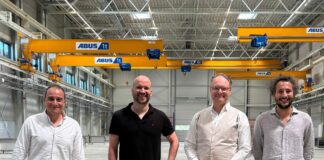 Image of 4 men in front a manufacturing machine