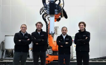 A group of 4 men in front of a machine