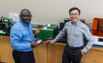 Two men in front of a 3D printer