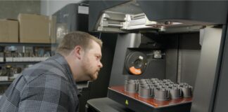 Man looking at parts in a 3D printer