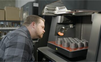 Man looking at parts in a 3D printer