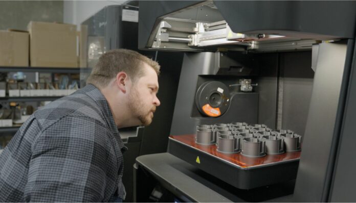Man looking at parts in a 3D printer