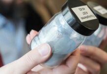 Woman looking at powder in a small container