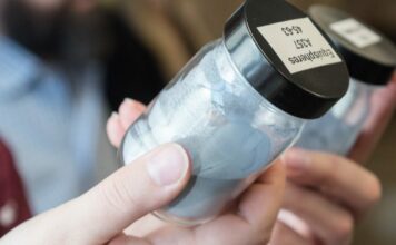 Woman looking at powder in a small container