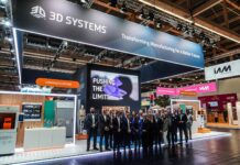 What do 3D Systems’ 2025 developments tell us about 2026? A group of people gathered for a picture in front of a booth