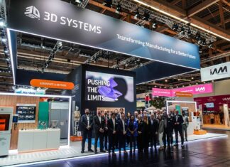 What do 3D Systems’ 2025 developments tell us about 2026? A group of people gathered for a picture in front of a booth