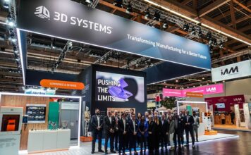 A group of people gathered for a picture in front of a booth