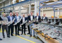 A group of Airbus employees holding a Titanium 3D printed part for the Airbus A350