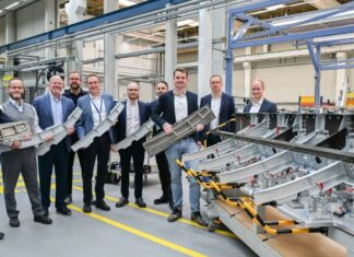 A group of Airbus employees holding a Titanium 3D printed part for the Airbus A350