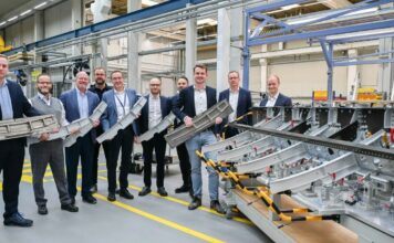A group of Airbus employees holding a Titanium 3D printed part for the Airbus A350