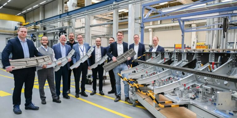 Équipe Airbus présentant une grande pièce en titane imprimée en 3D pour l’A350