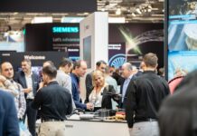 Events | 2026 Outlooks Group of people discussing on a booth an industry event