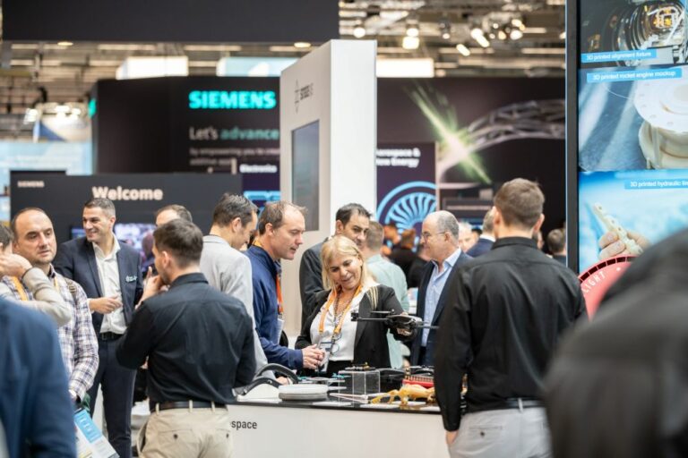 Group of people discussing at a booth during an industry event