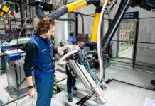 Two men operating a robot 3D printer