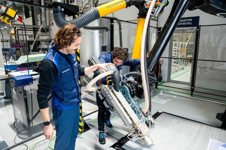 Opérateurs et robot de fabrication au campus de fabrication additive de BMW Group