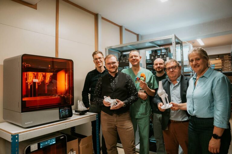 A group of people beside a 3D printer at PrintPlace.