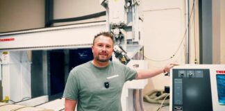 Man staning in front of a CNC machine