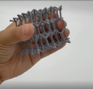 A hand holding a polymer 3D printed part