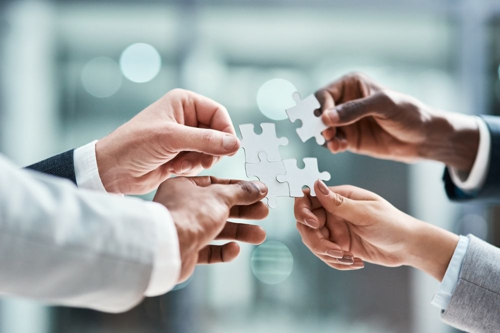Mains assemblant les pièces d’un puzzle