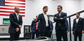 One man showing an aircraft prototype to a group of 6 men
