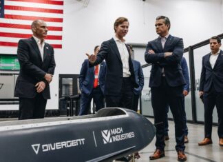 One man showing an aircraft prototype to a group of 6 men