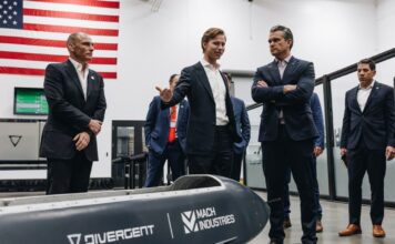 One man showing an aircraft prototype to a group of 6 men
