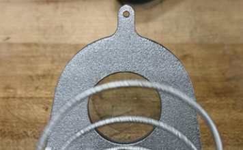 Close-up of the additively manufactured titanium deployment spring inside the JPL Additive Compliant Canister (JACC), highlighting the integrated mechanism design made possible by additive manufacturing.