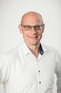 Picture of a white man wearing glasses. Business man