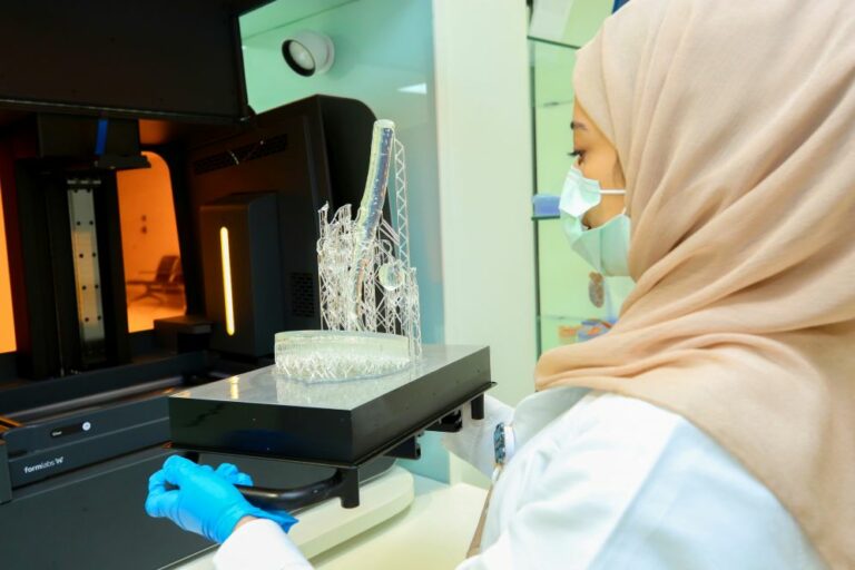 Woman removing a 3D printed part from the 3D printer