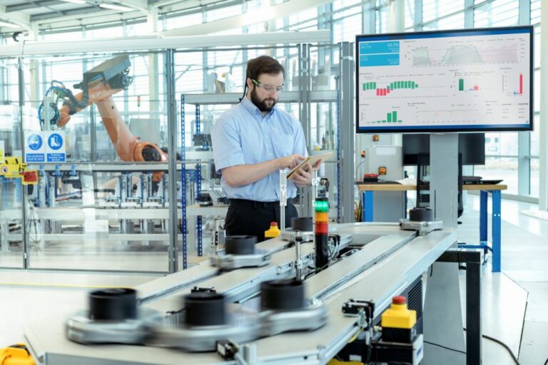 Robot industriel et écran de contrôle dans une cellule de fabrication