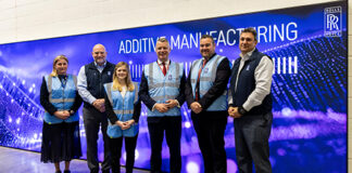 Group of people (2 women and 3 men) taking a picture at the entrance of a center