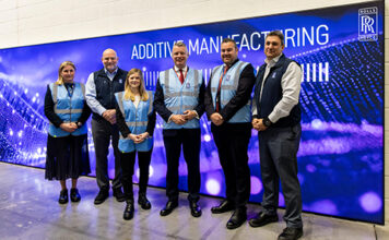 Group of people (2 women and 3 men) taking a picture at the entrance of a center