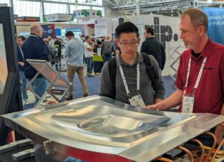 One expert showing a booth visitor a Cut Layer part on display at RAPID+TCT 2026