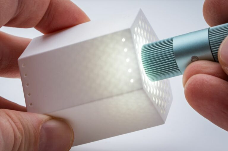 A ceramic gyroid structure illuminated to reveal its internal channels.