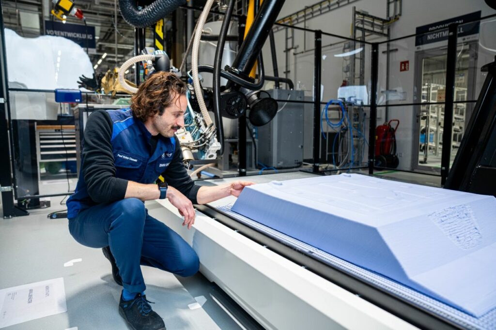 Man looking at a part being 3D printed part