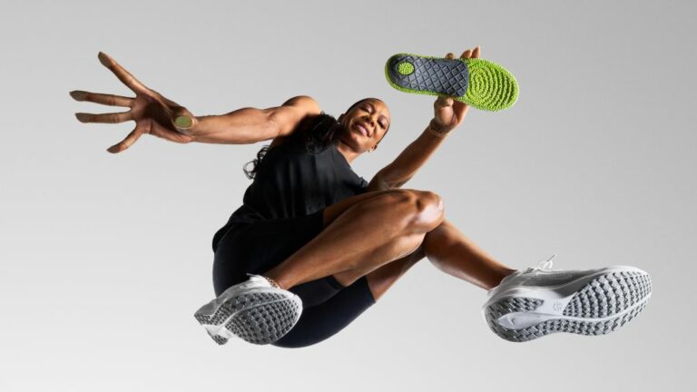 Athlete in motion holding an insole.